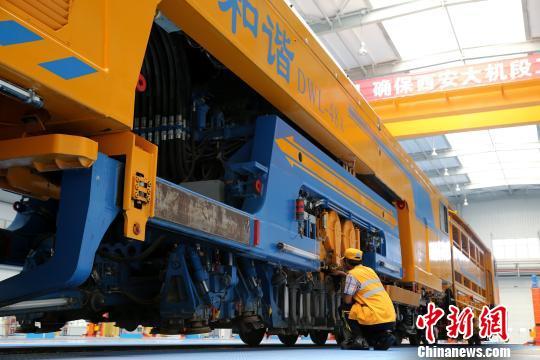 圖為工人正在清理大型養(yǎng)路機械?！堖h 攝
